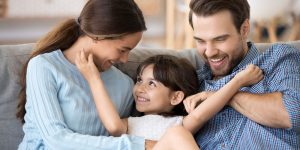 cute little girl laughing with parents