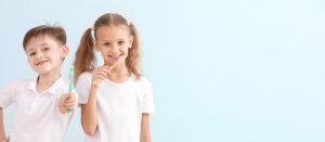 little children brushing teeth and smiling