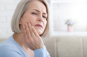 Teeth problem | Woman feeling tooth pain | Closeup of beautiful middle-aged suffering from strong toothache | Attractive female feeling painful toothache. Dental health and care concept.